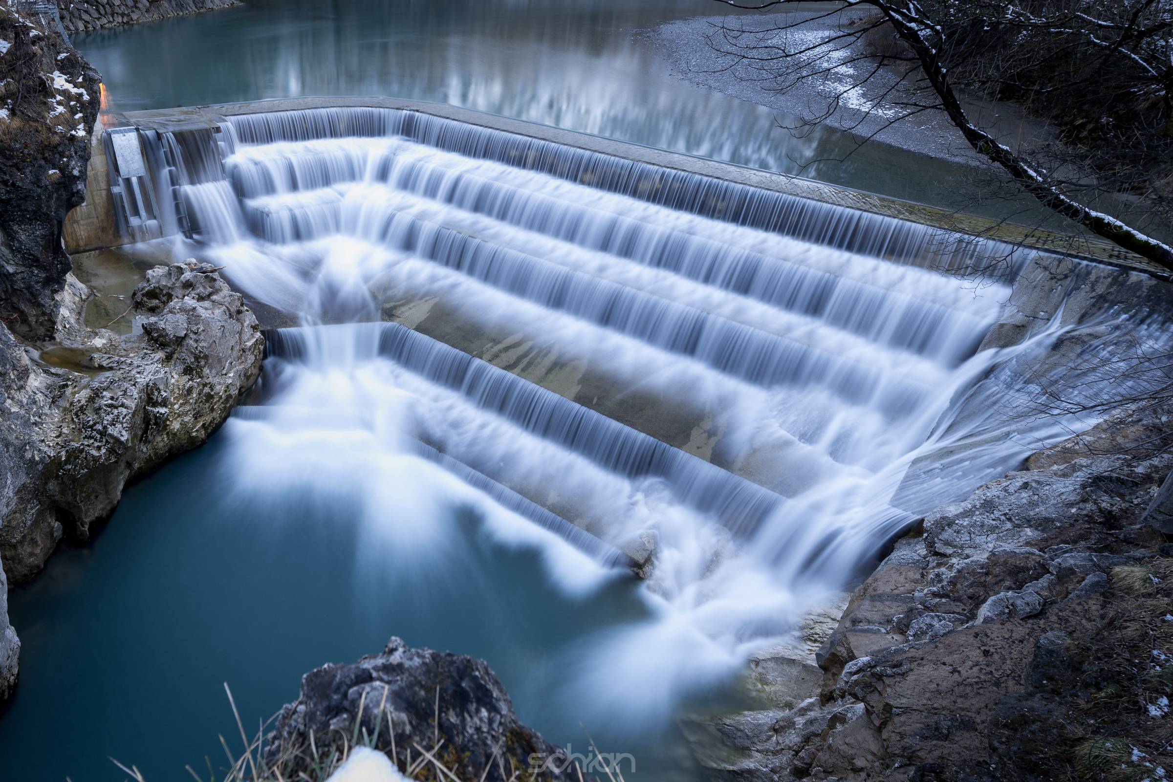 water in motion flowing over fall with steps at winter