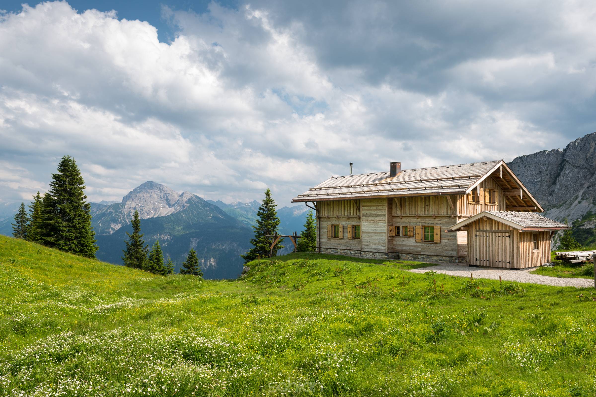 wooden timber chalet house on austrian mountains at spring