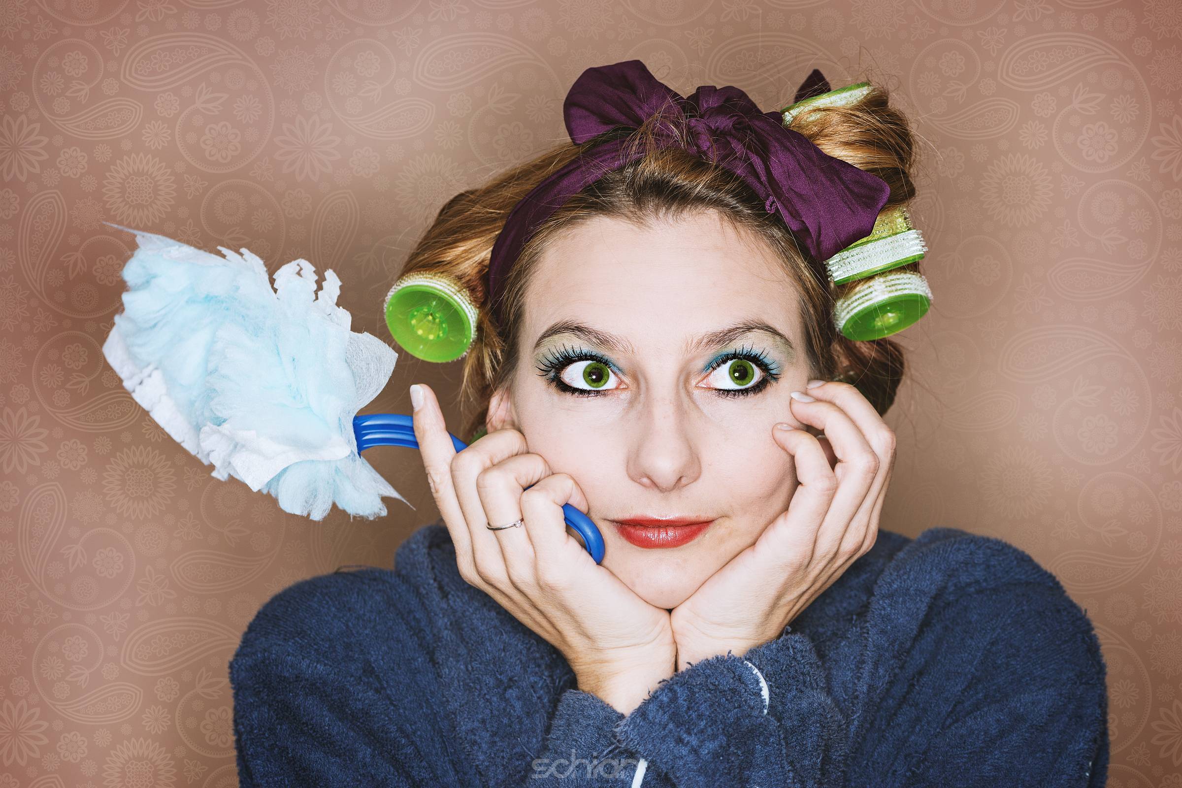 desperate housewife with hair roller, bathrobe and feather duster