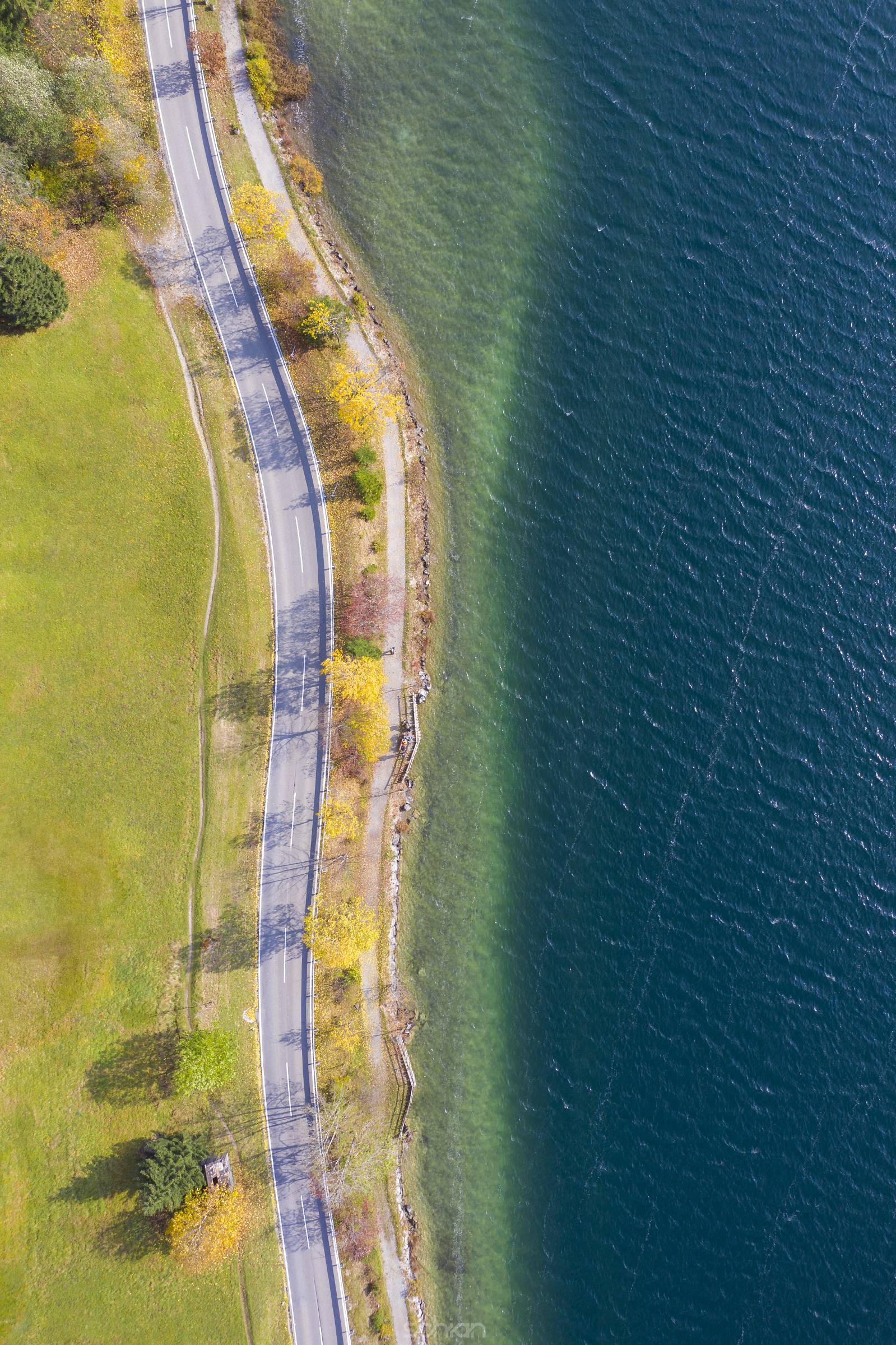 Aerial picture from above of street and lake promenade Haldensee in autumn